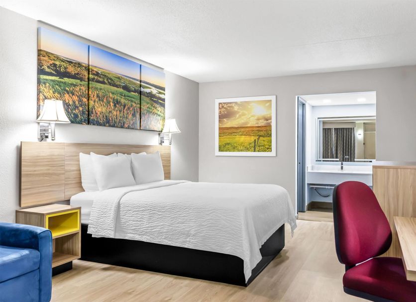 Days Inn by Wyndham Salina South room with bed, desk, TV and bathroom doorway in Salina