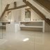 Domaine de Bayeux room with exposed beams, white vanity, and glossy tiled floor in Bayeux