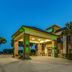 Quality Inn West Plano - Dallas in Plano, exterior entrance with green-lit canopy at dusk