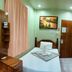 Coron Sanho Pension House, Coron: simple single room with bed, vanity desk, mirror, and wall art
