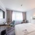 Premier Inn Stuttgart Airport room with a large bed, desk, chair, and window with curtains in Leinfelden-Echterdingen
