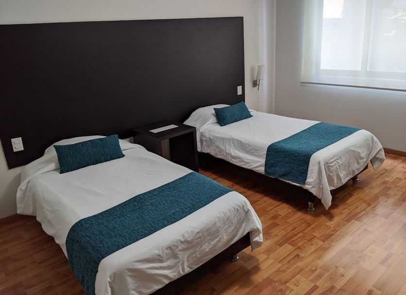 Grupo Kings Suites Musset in Mexico City, twin room with two single beds and teal bed runners