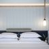 Savoy Sea Side Hotel Tel Aviv guest room with a neatly made bed and pendant lights