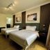 EGI Resort and Hotel, Lapu-Lapu City: twin beds in a guest room with wood floors and warm lighting