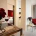 Howard Johnson by Wyndham Parkland Hotel Dalian suite with red lounge chair, chaise, desk and bedroom view