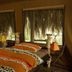 Crater Forest Tented Camp in Karatu: twin beds in a tented guest room with large windows and forest views