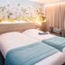 Hôtel Mercure Trouville-sur-Mer room with twin beds, floral wall art, and blue bedding in Trouville-sur-Mer.