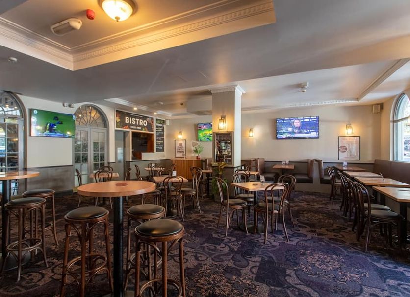 Royal Exhibition Hotel Sydney bistro-style lounge with tables, stools and wall-mounted TVs