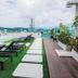 The Aim Patong Hotel rooftop pool deck with loungers, city views, and landscaped seating area in Patong