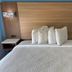 Jacksonville Inn & Suites hotel room with king bed, wood headboard, and bedside lamps in Jacksonville