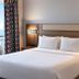 Silver Beach Hotel in Saint Joseph guest room with neatly made bed, bedside lamps and window view