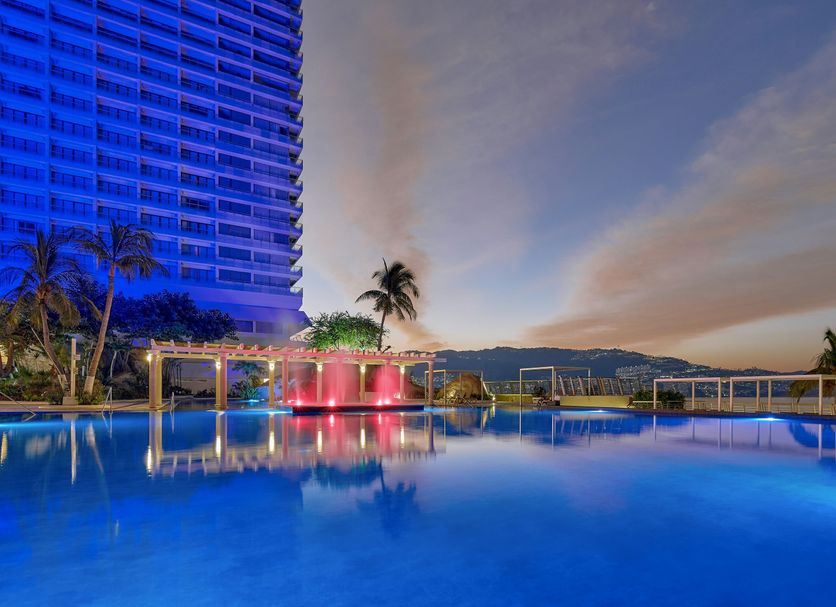 Fiesta Americana Acapulco Villas rooftop pool at dusk with ocean and mountain views in Acapulco