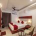 Sathyam Oasis, Tiruchirappalli: modern hotel room with double bed, bedside lamps, ceiling fan and curtains