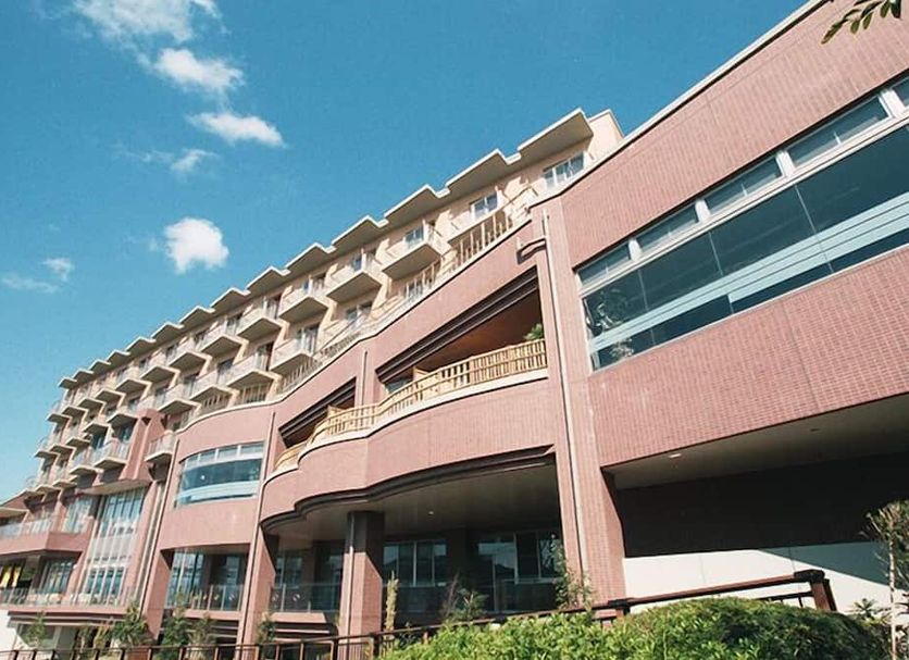Kaikyo View Shimonoseki in Shimonoseki with a pink facade, balconies, and a blue sky