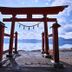 Onsen Yupopo in Semboku: red torii gate overlooking a calm lake with mountains in the distance