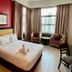 Puteri Bay Hotel in Malacca: guest room with bed, red accent wall, chairs by window