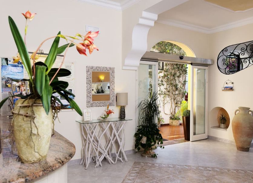 Hotel Casa Di Meglio lobby with arched doorway, potted plants, and decorative vases in Casamicciola Terme
