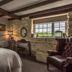 Widbrook Grange, Bradford-on-Avon: cozy guest room with stone wall, exposed beams, desk, and leather chair