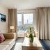 Best Western Plus Welcome Hotel Frankfurt room with sofa, window city view, and seating area in Frankfurt am Main