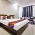 Hotel Taj Heritage in Agra guest room with bed, patterned headboard, desk, chairs and air conditioner