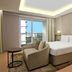 DoubleTree Suites by Hilton Bengaluru Outer Ring Road room with bed, armchair, and city-view balcony