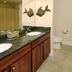 Crystal Towers Gulf Shores bathroom with double vanity, granite countertop, and walk-in shower