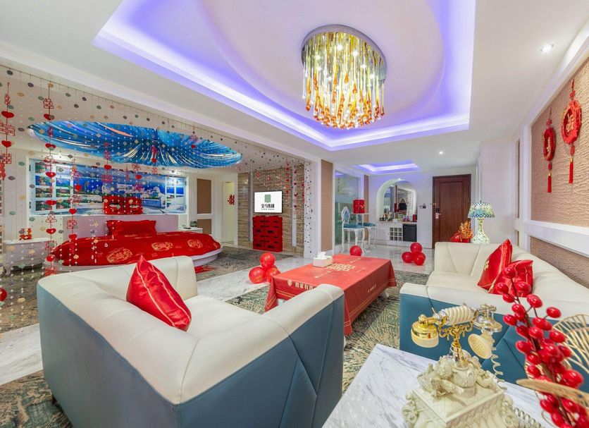 Real Madrid Holiday Island Style Hotel (Haikou Qilou Old Street) room with red-themed decor and seating