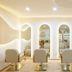 La Vela Saigon Hotel in Ho Chi Minh City salon with beige chairs, arched mirrors, and warm lighting