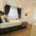 Hotel Melisa, Bozburun guest room with two beds, large windows, curtains, and wood flooring