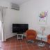 Karibu Aruba in Noord guest room with orange chairs, small table, TV, wall art and air conditioner