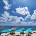 Coral Princess Hotel & Dive Resort in Cozumel with turquoise umbrellas and lounge chairs by the ocean