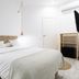 Bruc & Bruc Barcelona guest room with white bed, woven headboard, wood nightstand and TV