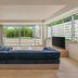 Iraph Sui, A Luxury Collection Hotel, Miyako Okinawa living room with blue sofa, TV, and large garden-view windows