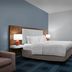 Hampton Inn Russellville guest room with king bed, desk, and blue patterned carpet