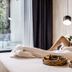 Krista Boutique Hotel Buenos Aires guest relaxing in bed with balcony and breakfast tray