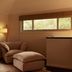 28 Degrees Byron Bay - Adults Only lounge with armchair, ottoman, lamp and view into bathroom