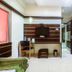 Hotel Golden Treat Indore room with two beds, wall-mounted TV, desk, and hallway view