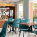 Deltour Hotel Le Puy En Velay dining area with teal chairs and breakfast counter in Le-Puy-en-Velay