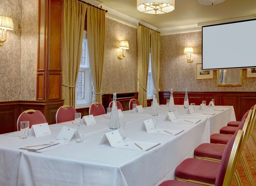 Best Western Plough & Harrow Hotel in Birmingham meeting room with U-shaped table, red chairs, and screen