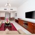 Star Metro Deira Hotel Apartments in Dubai living room with sofa, coffee table, TV and dining area