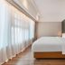 Dongguan Huaxi International Hotel guest room with king bed and floor-to-ceiling sheer curtains in Dongguan