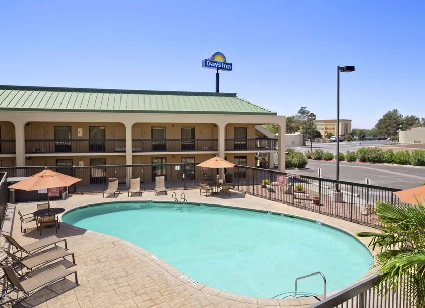 Days Inn by Wyndham Las Cruces outdoor pool with lounge chairs and umbrellas