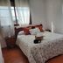 Hostal Rural La Plata Parking Incluido room with floral bedspread, wooden furniture and windows in Arcos de la Frontera