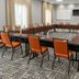 Fairfield Inn & Suites by Marriott Calhoun meeting room with U-shaped conference tables and orange chairs