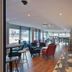 Travelodge London Kingston Upon Thames bar cafe seating area with tables, chairs, and large windows
