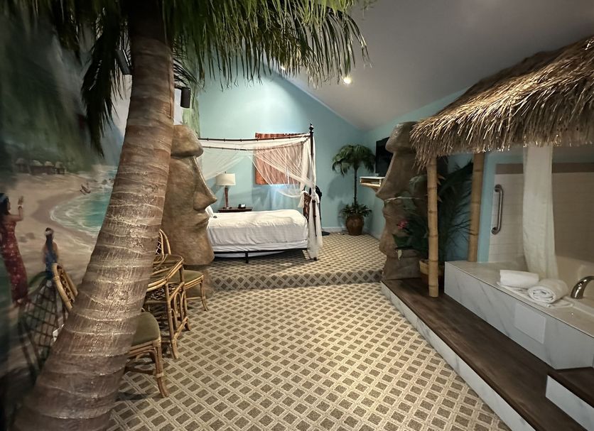 Chateau Avalon Hotel & Spa in Kansas City spa suite with four-poster bed, palm tree and soaking tub