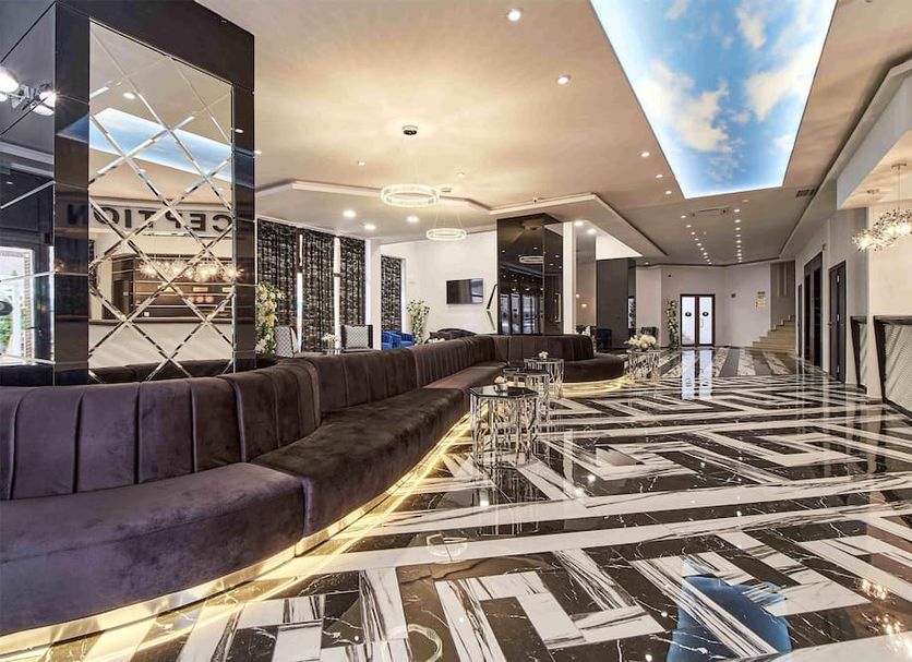 Prestige Hotel & Aquapark lobby in Golden Sands with sleek seating and geometric black-and-white floor