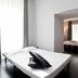 Suite Art Navona in Rome: minimalist guest room with a bed, bedside table, and doorway to an adjoining room