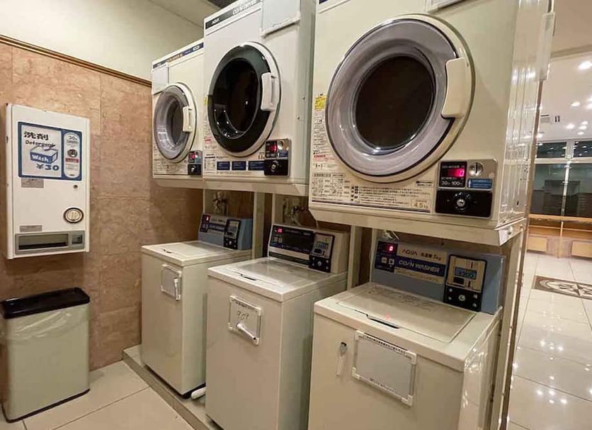Toyoko Inn JR Yokohama sen Sagamihara Ekimae laundry room with stacked washers and dryers in Sagamihara