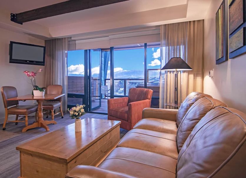 Newpark Resort Park City suite with sofa, dining table and balcony city views